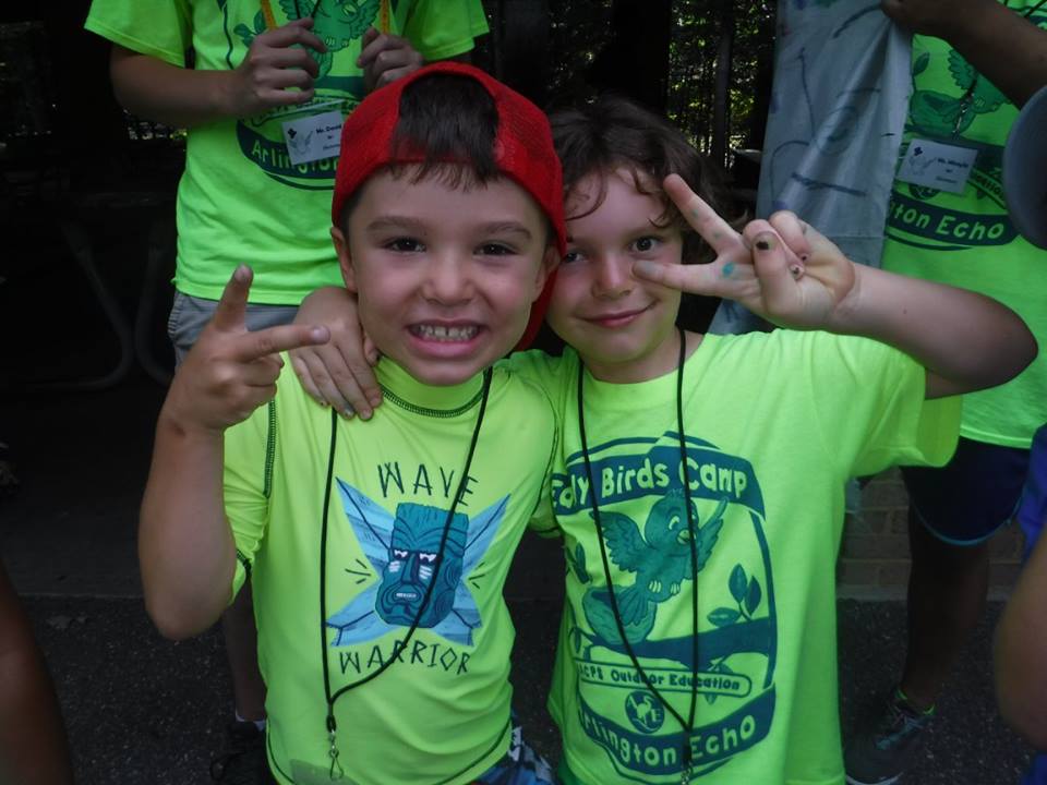 Two campers smiling wearing neon yellow t-shirts. 